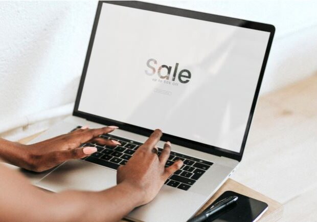 Hands on laptop with sale screen