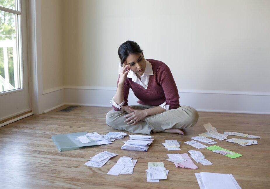 Woman organizing bills on the floor