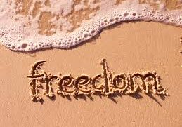 Beach sand with "freedom" and sea foam